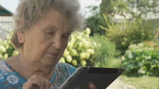 Gümüş Dijital tablet tutan yaşlı büyükanne — Stok video