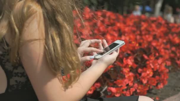 Молода дівчина зі смартфоном на відкритому повітрі — стокове відео