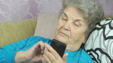 Yaşlı kadın bir cep telefonu kapalı tutan