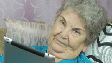 Yaşlı kadın bir dijital tablet kapalı tutan