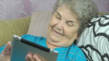 Yaşlı kadın bir dijital tablet kapalı tutan