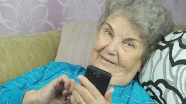 Yaşlı kadın bir cep telefonu kapalı tutan