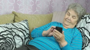 Cep telefonu kullanan yaşlı bir kadın.