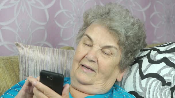 Пожилая женщина с помощью мобильного телефона — стоковое видео
