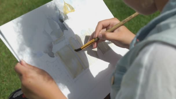 Flicka som målar en bild av kyrkan utomhus — Stockvideo