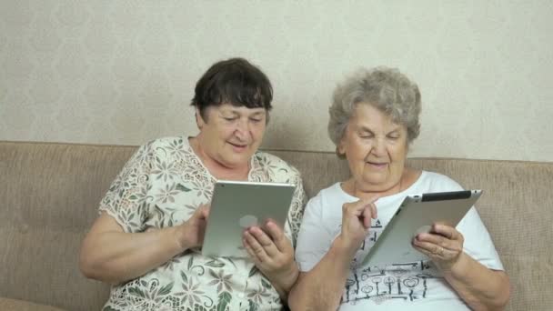 Dos mujeres mayores sosteniendo las tabletas digitales — Vídeo de stock