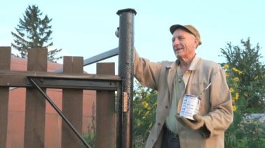 Siyah boya ile demir çitleri boyamak işçi