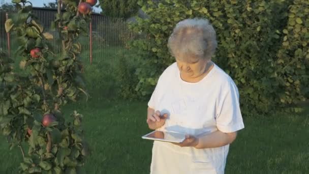 Mulher idosa 80s segurando tablet computador ao ar livre — Vídeo de Stock