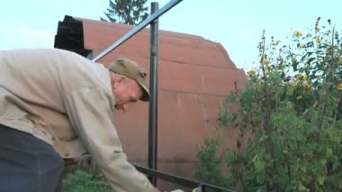 Yetişkin adam siyah boya ile demir çit boyalar