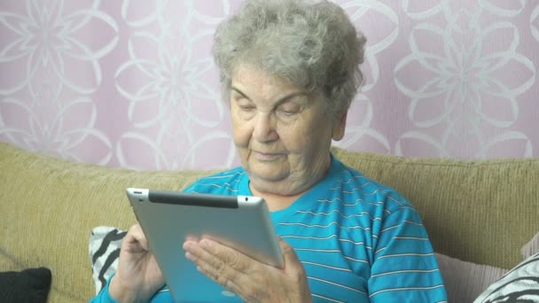 Mulher idosa que utiliza um comprimido de computador — Vídeo de Stock