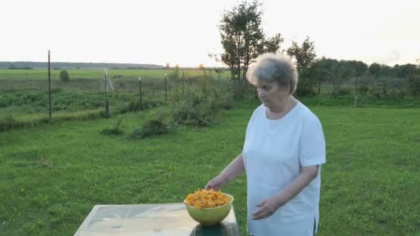 Женщина, несущая миску с песнопениями грибов — стоковое видео