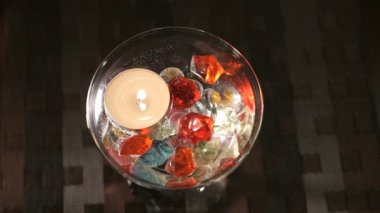 Bir cam mum yanan değerli taşlar dağılmış. Teklif elleri ve kalp