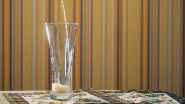Jet de cerveza ligera llena un vaso transparente sobre la mesa — Vídeo de stock