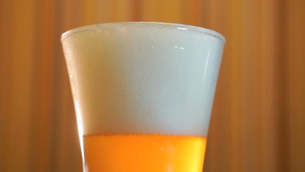Il y a un verre transparent de bière légère sur la table 