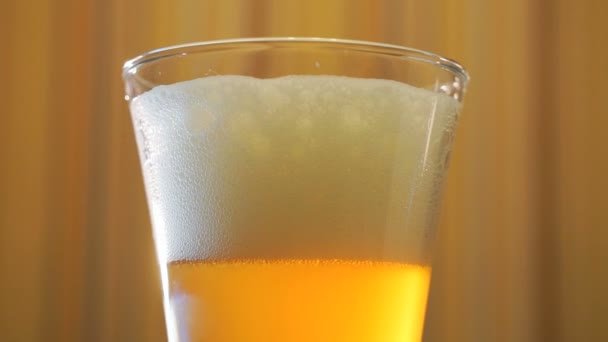 Jet de bière légère remplit un verre transparent sur la table 