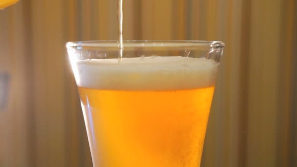 Jet de cerveza ligera llena un vaso transparente sobre la mesa — Vídeo de stock