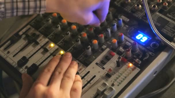 DJ works on the mixer console. Hand adjusting audio mixer — Stock Video