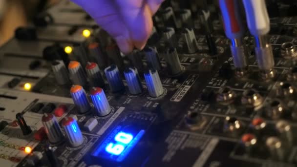 DJ funciona no console do mixer. Mão ajustando misturador de áudio — Vídeo de Stock