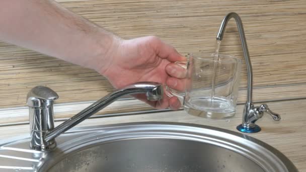 Hand is pouring a glass of drinking water from the filter — Stock Video