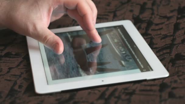 Homem lê notícias usando seu tablet — Vídeo de Stock