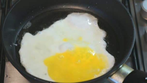 El proceso de freír huevos en una sartén. Skillet está en la encimera. Primer plano. — Vídeos de Stock