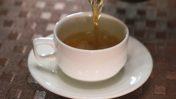 Наливання чорного чаю в білий порцеляновий кухоль — стокове відео