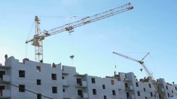 Guindaste de construção, trabalhadores trabalham na construção civil — Vídeo de Stock