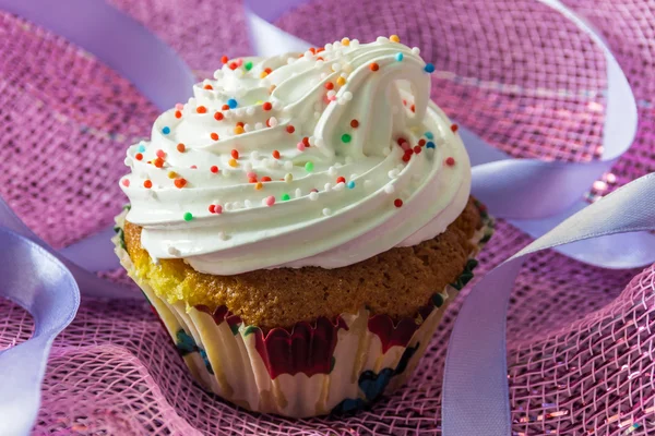 Bolo de muffin saboroso com creme de proteína, decorado com polvilhas de confeitaria coloridas — Fotografia de Stock