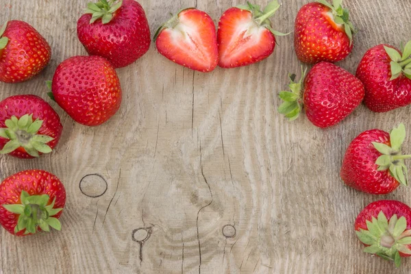 Verstreute Erdbeeren auf Holztisch (kann als Hintergrund verwendet werden, Karte) — Stockfoto