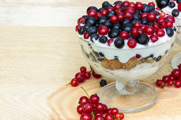 Sobremesa com creme e bagas frescas (groselhas vermelhas e pretas, mirtilo ) — Fotografia de Stock