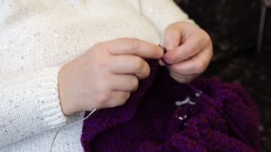 Kadın örgü iğneleriyle ceket örüyor. Kadın eli ve örgü..