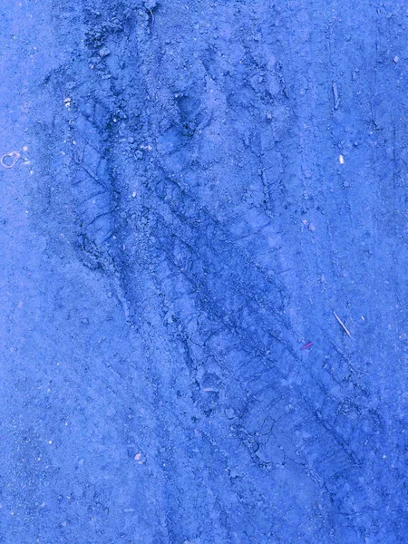 Faixas de pneu azul no fundo de pedra de cascalho estrada azul — Fotografia de Stock