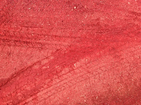 Červené stopy pneumatik na silniční štěrk kamenné pozadí — Stock fotografie