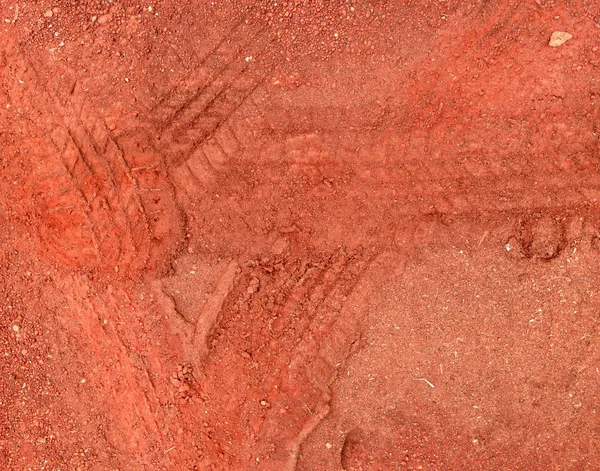 Czerwone ślady opon na tle kamienny żwir drogi — Zdjęcie stockowe