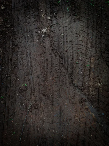Faixas de pneu preto na estrada cascalho pedra fundo — Fotografia de Stock