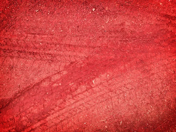 Červené stopy pneumatik na silniční štěrk kamenné pozadí — Stock fotografie