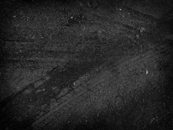 Черные следы шин на фоне дорожного щебня — стоковое фото