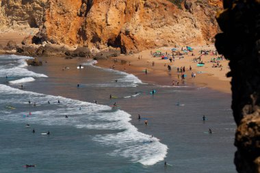 Yaz boyunca Sagres Burnu 'ndan Tonel Sahili' ne kadar birçok küçük sörfçü Algarve, Portekiz.