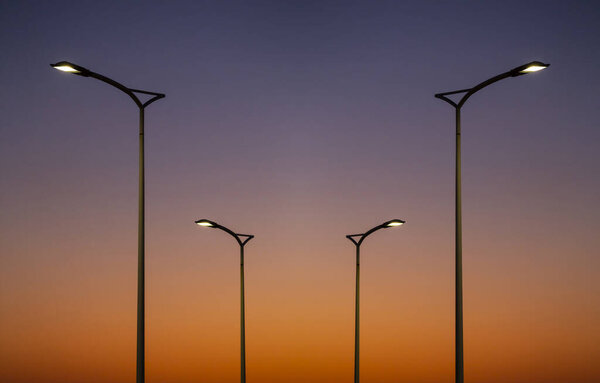 Street lamps silhouette at sunset, Vicentine Coast, Alentejo, Portugal.