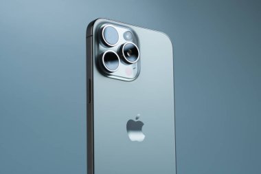 Apple iPhone 15 Pro Max, arka planda gri bir arka plana yerleştirilmiş üç kameralı bir akıllı telefonun profesyonel fotoğrafı..