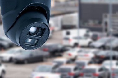 Bir güvenlik kamerası park halindeki birçok araçla dolu büyük bir otoparka odaklanmıştır. Tüm gün boyunca güvenliği sağlamak ve faaliyetleri izlemek için bölgeyi kaydediyor..