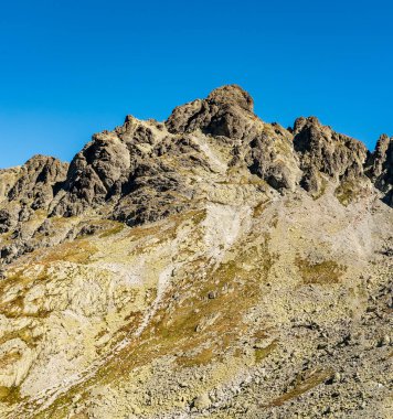 Diva veza dağ zirvesi ve Prielom eyeri, Slovaki 'deki Vysoke Tatry dağlarında sonbaharda Bielovodska dolina vadisinin en yüksek kesiminde Zamrznute pleso Gölü üzerindeki yürüyüş parkurundan alınmıştır.