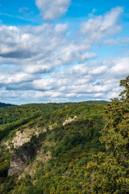 Orman, kaya oluşumlarıyla kaplı tepeler, Hardeggska vyhlidka bakış açısı ve Çek Cumhuriyeti 'nin Podyji milli parkında Avusturya' nın Hardegg kentinin yukarısındaki bakış açısından bulutlarla kaplı mavi gökyüzü