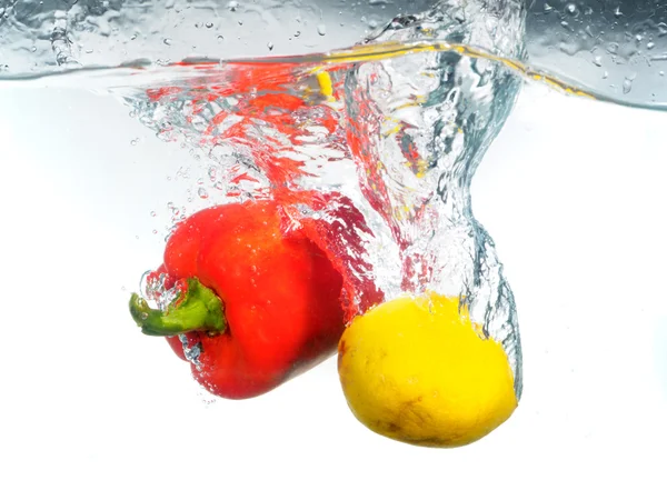 Goutte de poivron rouge et de citron dans l'eau — Photo