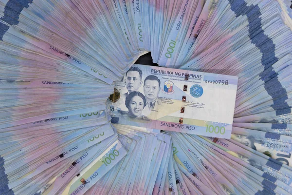 A pile of one thousand Philippines banknotes. Cash of Thousand