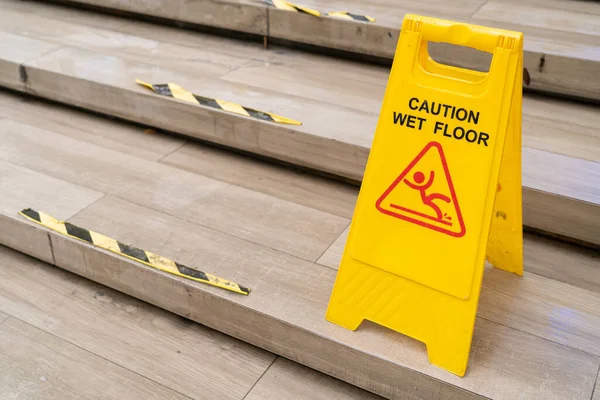Sarı Dikkat ıslak zeminde kaygan zemin tabelası. Halka açık alanda güvenlik uyarısı. Güvenlik Uyarısı Konsepti.
