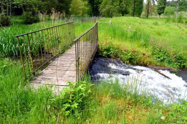 Ahşap ve demir yaya köprüsü eau bir ders üzerinde.