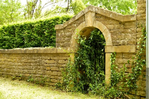 Entrada velha a pedras com um arco e um corrimão de ferro . — Fotografia de Stock