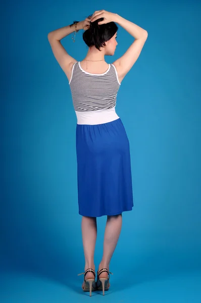 Beautiful young girl  posing on a blue background — Stock Photo, Image