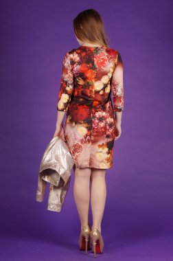 Güzel genç kız mor bir arka plan üzerinde poz